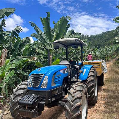 Os bananicultores que visitarem a 13ª edição da Feira Nacional da Bananicultura (Feibanana 2025), que acontece até o próximo dia 15 de maio, em Pariquera-Açu-SP, poderão conhecer de perto, no estande da estande da concessionária LS Tractor J.A. Máquinas, os recém lançados modelos de tratores, MT4 70 e MT2 27E. Os equipamentos contam com a tecnologia inovadora da LS Tractor, uma empresa sul-coreana, com o coração brasileiro que desenvolve soluções específicas para a cada necessidade e cultivo no campo. O estado de São Paulo é o maior produtor da fruta do Brasil, sendo que a região do Vale do Ribeira é o principal polo de cultivo, responsável por quase 70% do que é fornecido ao mercado. Segundo Ademir Chiquetti Júnior, gerente da concessionária J.A, de Mogi Mirim/SP, embora a demanda esteja aquecida, a falta de mão de obra especializada é um dos gargalos da produção, por isso a mecanização torna-se fundamental principalmente nesta região. “O Vale do Ribeira, tem como característica a topografia mais íngreme formada por montanhas. Desta forma os tratores da LS Tractor, que aliam tecnologia e robustez, foram pensados em facilitar o manejo diário em pequenas, médias e grandes propriedades, sendo especialmente útil em atividades que exigem manobras constantes”, detalhou Chiquetti Júnior. Novos tratores, múltiplos benefícios O trator MT4 70, recém apresentado ao mercado, se destaca por ser o único equipamento verdadeiramente utilitário de sua categoria, que combina versatilidade e inovação. Fabricado no Brasil, ele foi projetado para atender às diversas demandas da agricultura nacional, entre elas a fruticultura, horticultura. O modelo é o único em sua categoria, com o motor LS Diesel de quatro cilindros e potência de 62 cv com torque elevado. “Ele possui uma transmissão LS de 32 marchas a frente e 16 à Ré com super redutor integrado, um eixo dianteiro HD, que dá maior capacidade de carga e estabilidade no trabalho. Além de um sistema hidráulico com capacidade de levante 1.655 kg e controle remoto com vazão variável e ajuste de 0 à 35l/m, em uma das válvulas”, detalha, Astor Kilpp, Consultor de Marketing do Produto da LS Tractor. O modelo tem duas versões, plataformado (ROPs) e com cabine original de fábrica.