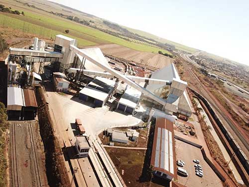  Na última década, terminal triplicou seu volume movimentado e, atualmente, recebe cerca de 70% das cargas desta commodity movimentadas pela companhia na FCA O Terminal Integrador de Guará, localizado no interior de São Paulo, celebra dez anos desde sua inauguração, em 2015, consolidando-se como um vetor estratégico para o desenvolvimento das operações de açúcar da VLI – companhia de soluções logísticas que opera ferrovias, portos e terminais. Primeiro ativo da companhia voltado exclusivamente para a movimentação do produto, na última década, o terminal mais que triplicou o volume transportado em suas instalações, saltando de 1,38 milhão para os atuais 4,5 milhões registrados na safra de 2024/2025. A marca reflete a relevância do terminal para o escoamento da produção nacional de açúcar. Isto porque, o volume transportado por meio do ativo na última safra com destino às exportações no Terminal Integrador Portuário Luiz Antonio Mesquita (Tiplam) correspondeu a cerca de 70% do total de 6,2 milhões de toneladas movimentadas na Ferrovia Centro-Atlântica (FCA) pela VLI na temporada 2024/2025. O Terminal Integrador de Guará escoa açúcar VHP (Very High Polarization), fornecido por 29 usinas. Case de cocriação Em 2020, a VLI inaugurou um novo armazém no terminal, desenvolvido em parceria com a Tereos, uma das empresas líderes no Brasil na produção de açúcar, etanol e energia a partir da biomassa da cana. Com a instalação, atualmente, o terminal possui capacidade para armazenar 160 mil toneladas do produto e, aliado a um sistema integrado com tecnologia de ponta, faz com que o ativo tenha muito mais agilidade no escoamento das cargas para exportação rumo à Baixada Santista. “O Brasil é o maior produtor e exportador mundial de açúcar, com os estados do Sudeste, como São Paulo e Minas Gerais, responsáveis por boa parte deste volume. Por isso, o segmento é estratégico para a VLI. E foi justamente para acompanhar seu desenvolvimento que estruturamos o terminal em Guará, nosso primeiro ativo voltado exclusivamente para esta carga. Com suas modernas instalações, entregamos eficiência operacional que reflete diretamente nos resultados dos nossos clientes, que encontram mais competitividade na rota de exportação do produto via Santos”, afirma Marcelo Cardoso, diretor de operações da VLI para o Corredor Sudeste.