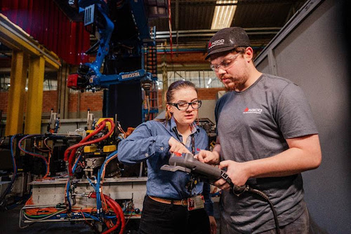O avanço tecnológico nas indústrias passa, cada vez mais, por uma liderança diversa e comprometida com a transformação contínua. Na fábrica da AGCO em Ibirubá (RS), a engenheira Marina Maletzke tem desempenhado um papel importante na modernização de processos ligados à manufatura. Com trajetória iniciada na companhia como engenheira júnior, Marina assumiu gradativamente responsabilidades na área de engenharia de manufatura e, em poucos anos, se tornou uma das responsáveis por modernizar processos e liderar iniciativas de automação industrial. Atualmente, integra o time responsável pelo setor de Backshop, que abrange desde a preparação dos componentes até a entrega final das peças pintadas. “Desde o início, busquei me envolver em projetos estratégicos. Em um ambiente com baixa automação, vi na tecnologia uma oportunidade para inovar e crescer profissionalmente, contribuindo com o desenvolvimento da fábrica e, ao mesmo tempo, da minha própria formação”, relata Marina. Entre os principais destaques da sua trajetória na AGCO está a participação ativa na produção da plantadeira Momentum, um dos projetos de maior complexidade técnica da unidade, em paralelo à ampliação da capacidade industrial da planta. “Mais de 60% dos conjuntos soldados são feitos de forma robotizada para garantir a qualidade e o desempenho. Foi um projeto desafiador porque estávamos expandindo a capacidade da fábrica ao mesmo tempo. Aprendemos muito e seguimos nos aperfeiçoando”, diz. Ao longo da carreira, Marina conta que enfrentou desafios relacionados a etarismo, gênero e à necessidade de constante afirmação técnica. Para ela, o posicionamento e a confiança foram fundamentais. “Em vários momentos fui a única mulher no time. Hoje, uso essas situações para abrir diálogo e estimular mudanças. A questão não é só sobre igualdade, mas sim sobre a participação de pessoas diversas”, afirma. A AGCO realiza diversas ações voltadas à equidade de gênero, formação de lideranças representativas e ampliação da diversidade nos times. Atualmente, as mulheres representam cerca de 40% dos colaboradores com até um ano de empresa na AGCO América do Sul, e iniciativas de capacitação, mentoria e desenvolvimento seguem em expansão. “Histórias como a da Marina demonstram como a diversidade impulsiona resultados concretos. A AGCO acredita na construção de um ambiente de trabalho inclusivo, colaborativo e com oportunidades reais para o crescimento de todos os talentos”, ressalta Angélica Kanashiro, vice-presidente de Recursos Humanos da AGCO para a América do Sul e Business Partner Global para a Massey Ferguson.